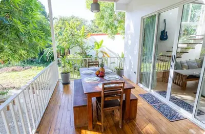 a wooden table and chairs on a porch at Kai Villa in Santa Teresa Beach