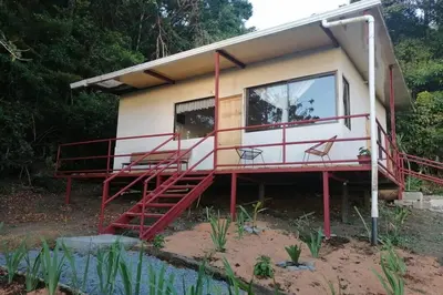 a small house with a balcony and stairs to it at Rainbow House in Monteverde Costa Rica