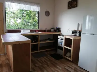 a kitchen with a counter and a refrigerator and a window at Rainbow House in Monteverde Costa Rica