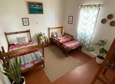a living room with two beds and a window at Rainbow House in Monteverde Costa Rica