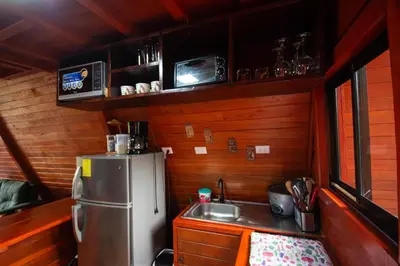 a kitchen with a refrigerator and a sink in a room at Betulio's Oasis in Fortuna