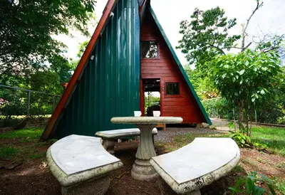 a small red and green house with a table and benches at Betulio's Oasis in Fortuna