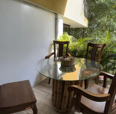 a glass table and chairs on a patio at Enchanted sonido de la selva in Quepos