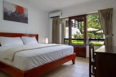 a bedroom with a large bed and a balcony at Fuego del Sol Beachfront Hotel in Jacó