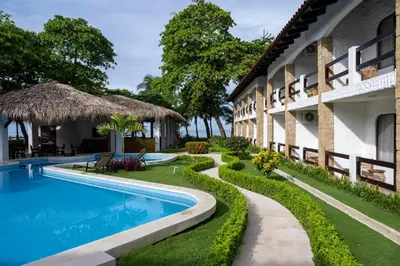 an exterior view of a resort with a swimming pool at Fuego del Sol Beachfront Hotel in Jacó
