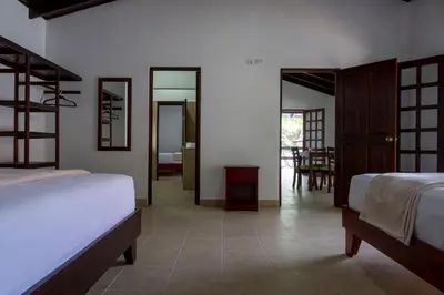 a bedroom with two beds and a dining room at Fuego del Sol Beachfront Hotel in Jacó