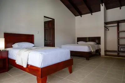 a bedroom with two beds and a mirror at Fuego del Sol Beachfront Hotel in Jacó