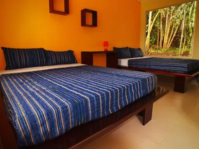 a bedroom with two beds and a window at Hotel Colores del Arenal in Fortuna