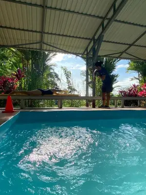 a person standing next to a swimming pool at Hotel Colores del Arenal in Fortuna