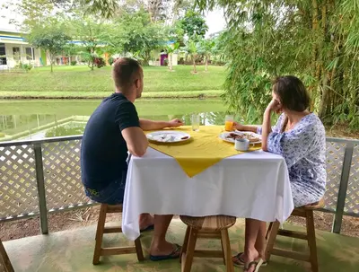 a man and a woman sitting at a table at Hotel Colores del Arenal in Fortuna