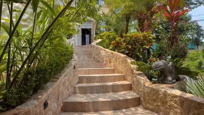 a set of stairs in a garden with plants at Issimo Suites (Adults Only) in Manuel Antonio