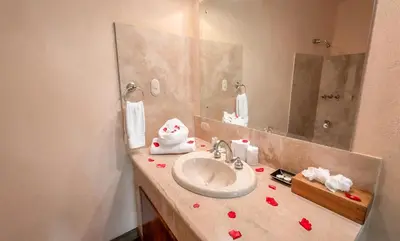 a bathroom with a sink and a mirror at Issimo Suites (Adults Only) in Manuel Antonio