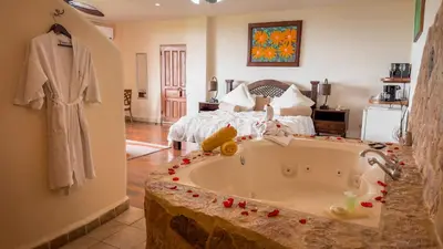 a bedroom with a large tub with a bed at Issimo Suites (Adults Only) in Manuel Antonio