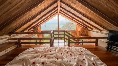a bed in a room with a large window at Issimo Suites (Adults Only) in Manuel Antonio