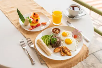 two plates of food on a table with eggs and vegetables at Issimo Suites (Adults Only) in Manuel Antonio