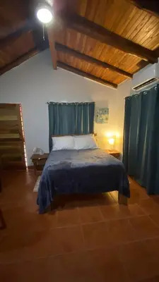 a bedroom with a bed with a blue blanket at Casa Rosada Nosara in Nosara