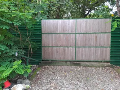 a wooden fence in front of a garden at Casa Rosada Nosara in Nosara