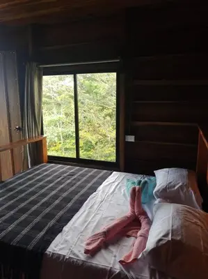 a bedroom with a bed with two towels on it at Cabaña Finca el Corteza in Fortuna