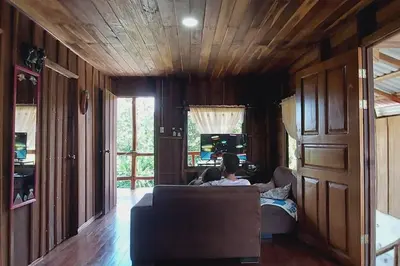 a person sitting on a couch in a living room at Cabaña Finca el Corteza in Fortuna