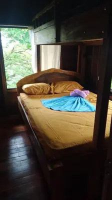 a bed with a wooden frame in a room at Cabaña Finca el Corteza in Fortuna