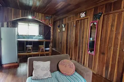 a living room with a couch and wooden walls at Cabaña Finca el Corteza in Fortuna