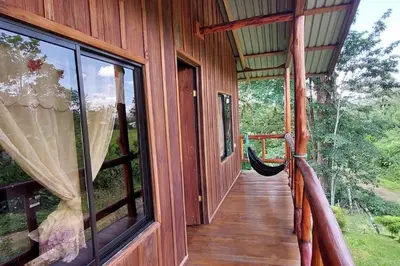 a porch of a wooden house with a window at Cabaña Finca el Corteza in Fortuna