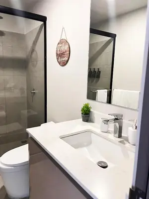 a bathroom with a sink and a toilet and a mirror at CityScape Properties 20th floor Studio 24-7 Concierge Amenities in San José