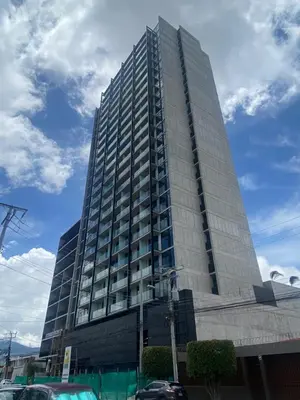 a tall building with cars parked in front of it at CityScape Properties 20th floor Studio 24-7 Concierge Amenities in San José