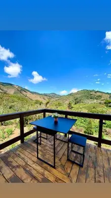 a blue table and a chair on a wooden deck at Cypress House Costa Rica in San Cristóbal Norte