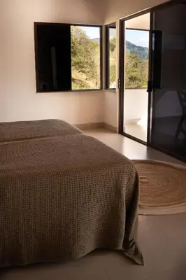 a bedroom with a bed and a large window at Finca Aquarius in Monteverde Costa Rica
