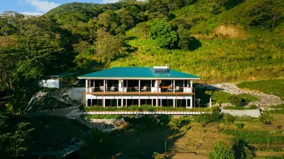 a house with a green roof on a hill at Finca Aquarius in Monteverde Costa Rica