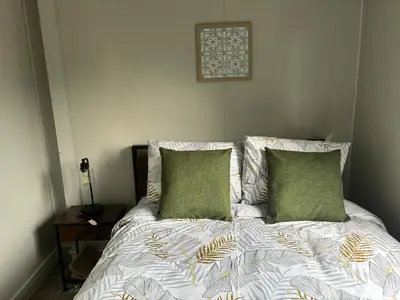 a bed with two green pillows on top of it at Gaspar Arenal Volcano in Fortuna