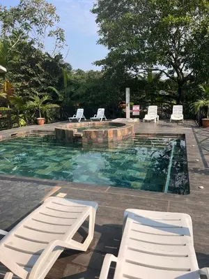 a swimming pool with two lounge chairs and a poolvisorvisor at Gaspar Arenal Volcano in Fortuna