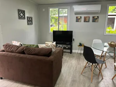 a living room with a couch and a glass table at Gaspar Arenal Volcano in Fortuna