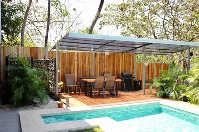 a patio with a table and a swimming pool at Z orro Tropical in Arbolito