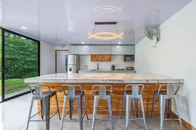 a kitchen with a large counter with stools around it at Z orro Tropical in Arbolito