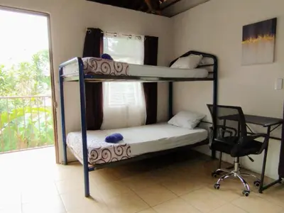 a bedroom with two bunk beds and a desk at Cabaña Dream House in Pejibaye