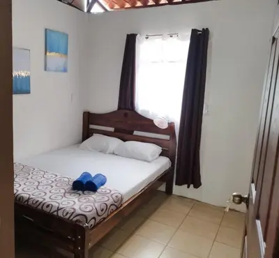 a bedroom with a bed with two blue shoes on it at Cabaña Dream House in Pejibaye