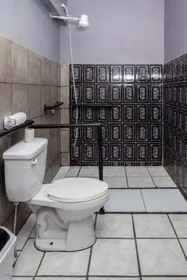 a bathroom with a toilet and a black and white tiles at San Isidro, Perez Zeledon - Hotel Dubai in San Isidro
