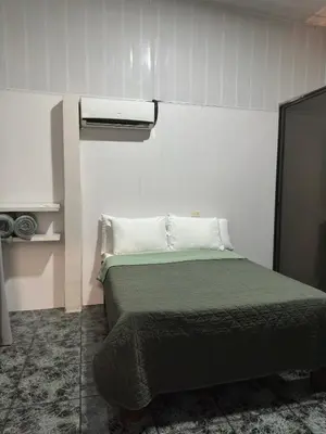 a bedroom with a bed with a green blanket at Casa Buen Agüero in San Antonio