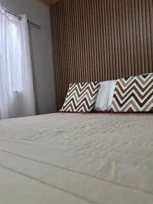 a bedroom with a white bed with pillows and a window at Casa Buen Agüero in San Antonio