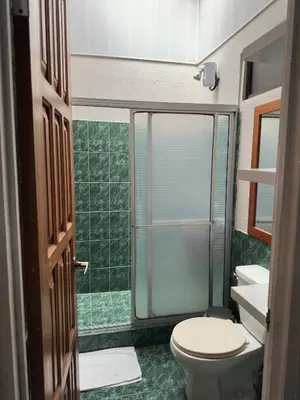 a bathroom with a toilet and a glass shower at Casa Buen Agüero in San Antonio