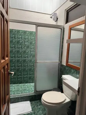 a bathroom with a toilet and a glass shower at Casa Buen Agüero in San Antonio