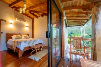 a bedroom with a bed and a glass door at Two Volcanoes Villa Fortuna in Fortuna