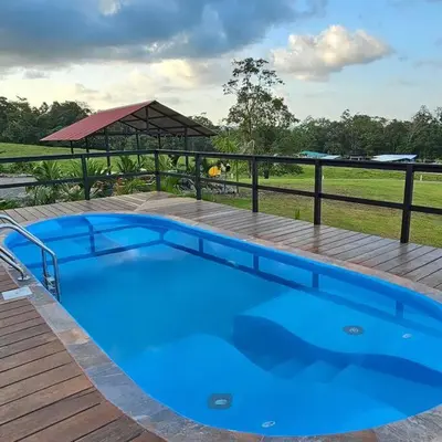 a large blue swimming pool on a wooden deck at Two Volcanoes Villa Fortuna in Fortuna