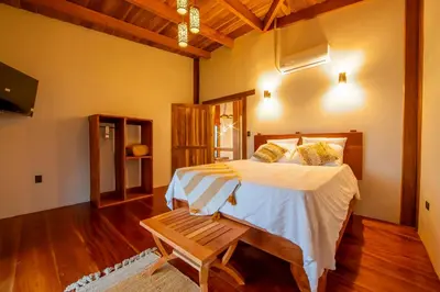 a bedroom with a bed and a bench in it at Two Volcanoes Villa Fortuna in Fortuna