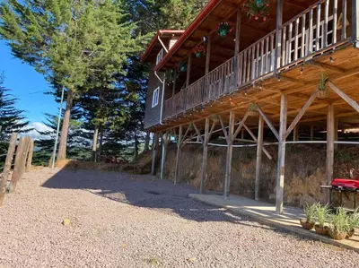 a large wooden building with a staircase on it at Cabaña Aurora – COZY Cabin with an Amazing view! in San Pablo