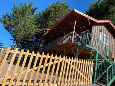 a wooden fence in front of a house at Cabaña Aurora – COZY Cabin with an Amazing view! in San Pablo