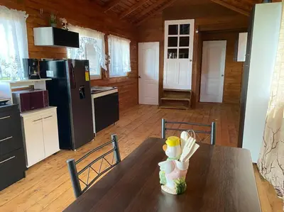a kitchen with a wooden table and a kitchen with a refrigerator at Cabaña Aurora – COZY Cabin with an Amazing view! in San Pablo