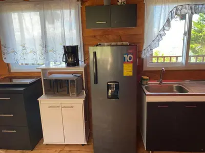 a kitchen with a refrigerator and a sink at Cabaña Aurora – COZY Cabin with an Amazing view! in San Pablo